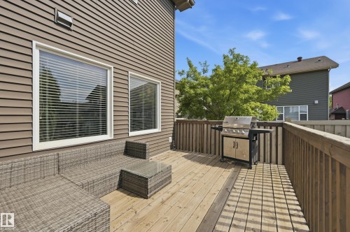 Spacious outdoor deck featuring natural wood decking, a wood railing, and an exterior of horizontal siding - 5430 Edworthy Way, Edmonton, AB - Outdoor With Deck Patio Veranda With Exterior