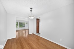 Dining area featuring wood-finish flooring and a central pendant light fixture - 