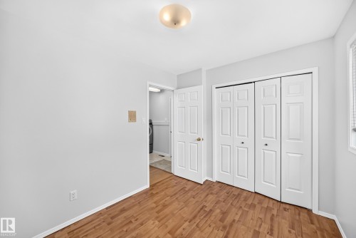 Room featuring wood-finish flooring, light grey painted walls, and a ceiling-mounted light fixture - 9843 188 Street, Edmonton, AB 
