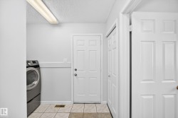 Utility space featuring light-toned tile flooring and white paneled doors - 