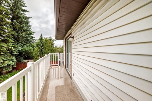 Exterior balcony featuring white railings, a sliding glass door, and a wall with horizontal siding - 9843 188 Street, Edmonton, AB 