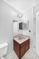 Vanity with a wood-finish cabinet and integrated sink, complemented by a polished chrome faucet - 