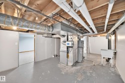 Utility area featuring an exposed beam ceiling, hot water heater, furnace, and a functional utility sink - 
