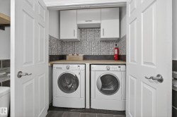 Compact laundry area featuring side-by-side appliances, upper cabinetry, a wood-finish countertop, and a tiled backsplash - 