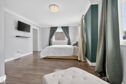 Spacious room featuring wood-finish flooring, two windows, and crown molding - 