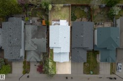 Residential property featuring a light-colored shingle roof and a concrete driveway - 