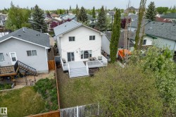 Rear exterior of a residence featuring white siding and a multi-level deck with white railings - 