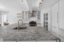 Spacious kitchen island featuring a dual-basin stainless steel sink and gooseneck faucet - 