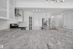 Kitchen island with a light-toned granite countertop and undermount sink - 