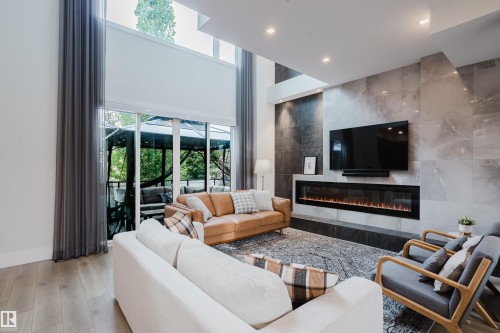 Living area featuring a floor-to-ceiling tiled fireplace surround with an integrated electric fireplace - 1313 Clement Crest, Edmonton, AB 