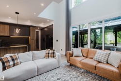 Open concept living area with high ceilings and expansive windows - 