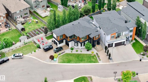 Modern architectural design featuring prominent gables, dark shingled roofs, and a mix of light and dark exterior finishes - 1313 Clement Crest, Edmonton, AB 