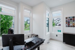 Light-filled room featuring multiple large windows with roller shades, light wood-finish flooring, white walls, and white trim - 
