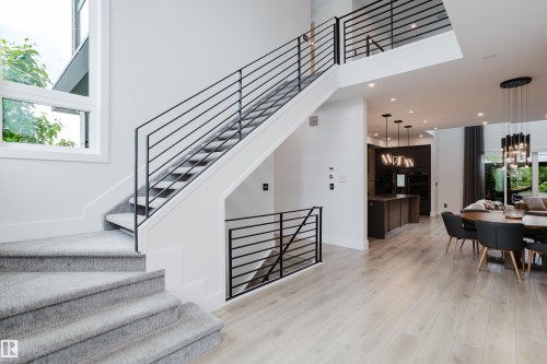 Contemporary staircase featuring black metal railings and carpeted treads - 1313 Clement Crest, Edmonton, AB 