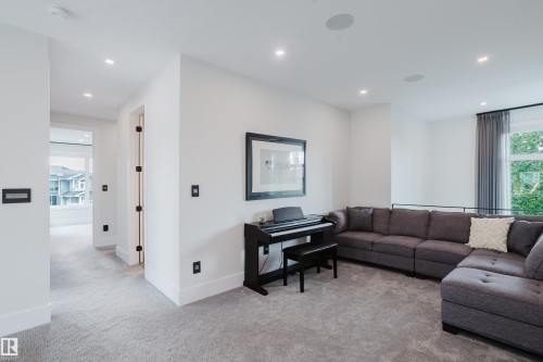 Carpeted upper-level landing featuring recessed lighting, a large window with privacy sheers, built-in ceiling speakers, and modern wall controls - 1313 Clement Crest, Edmonton, AB 