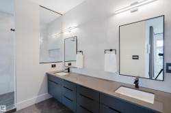 Dual floating vanities with integrated rectangular sinks, accented by matte black fixtures and under-mirror lighting - 