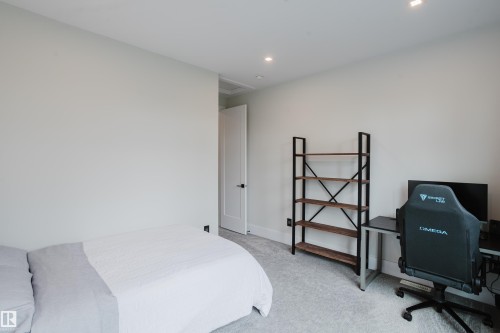 Neutral-toned room featuring a white interior door with black hardware, recessed ceiling lighting, light gray carpeting, and white baseboards - 1313 Clement Crest, Edmonton, AB 