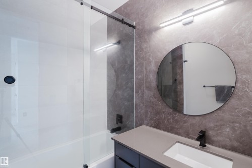 Contemporary bathroom featuring a vanity with a light gray countertop, undermount sink, and matte black faucet - 1313 Clement Crest, Edmonton, AB 