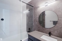 Contemporary bathroom featuring a vanity with a light gray countertop, undermount sink, and matte black faucet - 