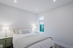 Bright interior room featuring a single window with roller shade, recessed ceiling lighting, and soft gray carpeting - 