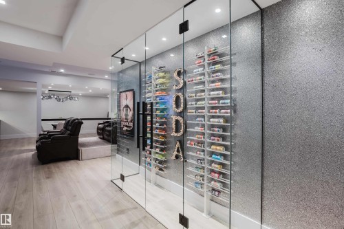 Glass-enclosed beverage display with multi-tiered shelving, set against a textured wall - 1313 Clement Crest, Edmonton, AB 