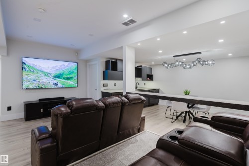 Entertainment area featuring light wood-finish flooring, recessed lighting, and a contemporary linear chandelier - 1313 Clement Crest, Edmonton, AB 