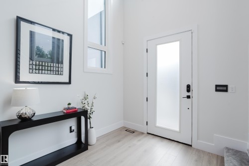 Modern entryway with wood-finish flooring and crisp white walls - 1313 Clement Crest, Edmonton, AB 