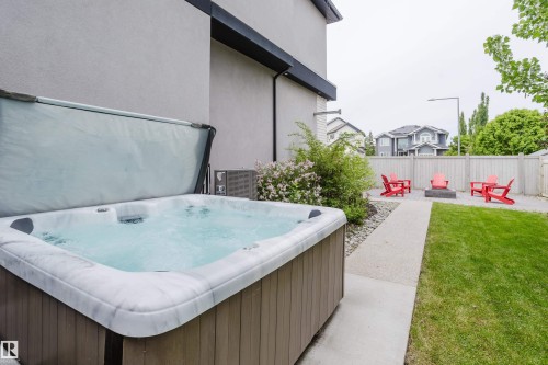 Outdoor spa with a light-colored shell and wood-finish exterior, set on a concrete patio - 1313 Clement Crest, Edmonton, AB 