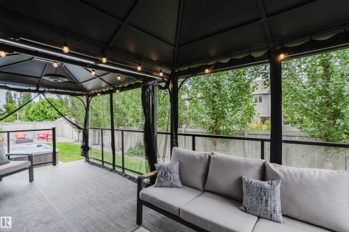 Deck featuring a black gazebo with string lighting, an integrated outdoor heater, and privacy screens - 1313 Clement Crest, Edmonton, AB 