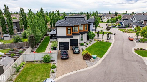 Contemporary two-story residence featuring a striking light stucco and wood-finish facade - 1313 Clement Crest, Edmonton, AB 