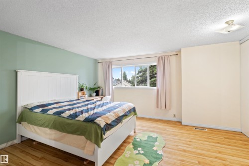 Bright interior space featuring wood-finish flooring, a window offering exterior views, a ceiling-mounted light fixture, and walls finished in a two-tone color scheme - 359 Kirkpatrick Crescent, Edmonton, AB 