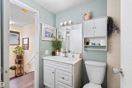 Bathroom featuring a white vanity with an integrated sink, polished chrome faucet, and a wall-mounted medicine cabinet with lower shelving - 359 Kirkpatrick Crescent, Edmonton, AB 