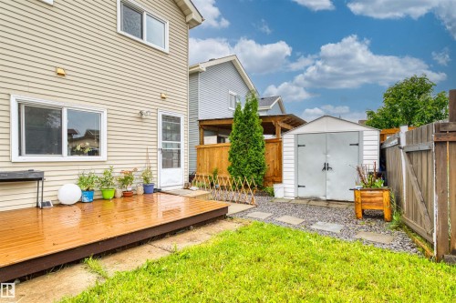 Private backyard featuring a wooden deck, manicured lawn, and a storage shed - 359 Kirkpatrick Crescent, Edmonton, AB 