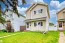 Two-story residence featuring light-colored siding, multiple windows, a covered front entry, and a white fence bordering the side yard - 359 Kirkpatrick Crescent, Edmonton, AB 
