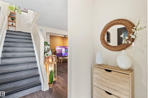 Staircase featuring dark wood-finish treads and white risers, complemented by white walls and wood-finish flooring - 359 Kirkpatrick Crescent, Edmonton, AB 