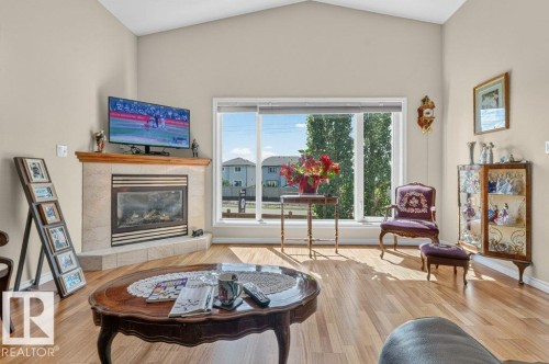 Vaulted ceilings enhance this living area featuring wood-finish flooring - 39 Wilkinson Place, Leduc, AB 