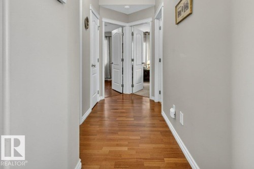 Hallway featuring wood-finish flooring, light grey painted walls, and white trim molding - 39 Wilkinson Place, Leduc, AB 