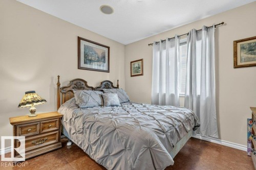 Bedroom featuring warm wall tones, a single window with drapes, and wood-finish flooring - 39 Wilkinson Place, Leduc, AB 