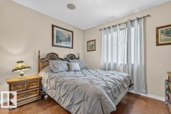 Bedroom featuring warm wall tones, a single window with drapes, and wood-finish flooring - 