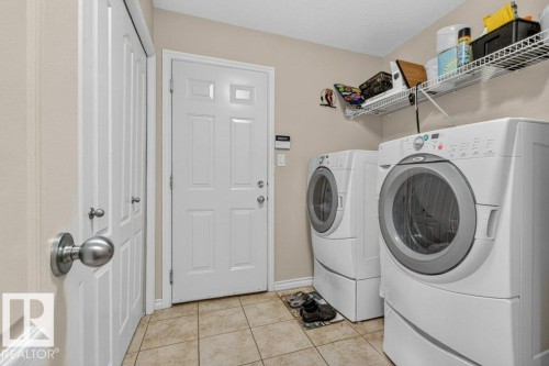 Dedicated laundry area featuring tile flooring - 39 Wilkinson Place, Leduc, AB 