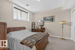 Bedroom featuring neutral-toned walls, carpet flooring, and white trim - 