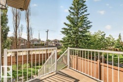 Wood-finish deck with white metal railing and steps, bordered by a wooden privacy fence - 