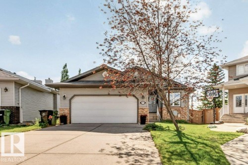 Exterior featuring a two-car garage, partial stone facade, and horizontal siding - 39 Wilkinson Place, Leduc, AB 