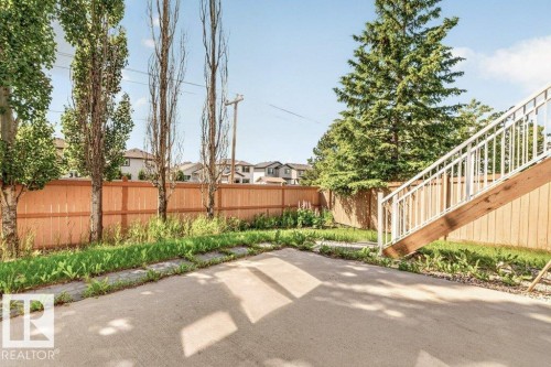 Concrete patio area with a wooden fence boundary - 39 Wilkinson Place, Leduc, AB 
