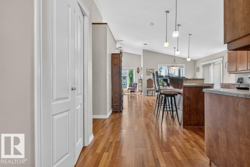 Open-concept living space featuring wood-finish flooring, vaulted ceilings, and recessed lighting - 39 Wilkinson Place, Leduc, AB 