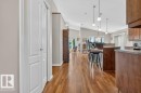 Open-concept living space featuring wood-finish flooring, vaulted ceilings, and recessed lighting - 39 Wilkinson Place, Leduc, AB 
