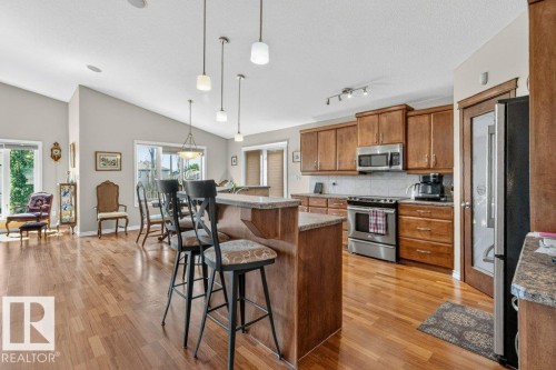 Open-concept kitchen and living area featuring wood-finish flooring - 39 Wilkinson Place, Leduc, AB 