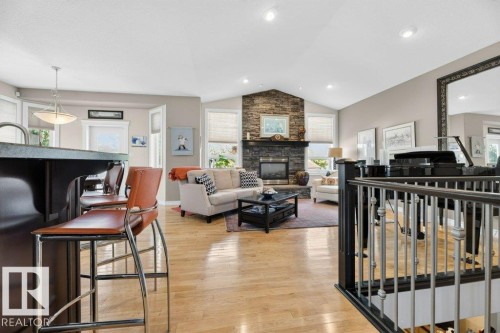 Open-concept living space featuring wood-finish flooring and a vaulted ceiling with recessed lighting - 5528 43 Street, Lamont, AB 