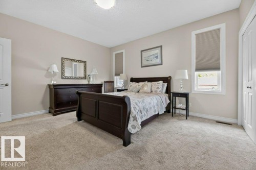 Spacious bedroom featuring light-colored walls, neutral carpet flooring, and a ceiling-mounted light fixture - 5528 43 Street, Lamont, AB 
