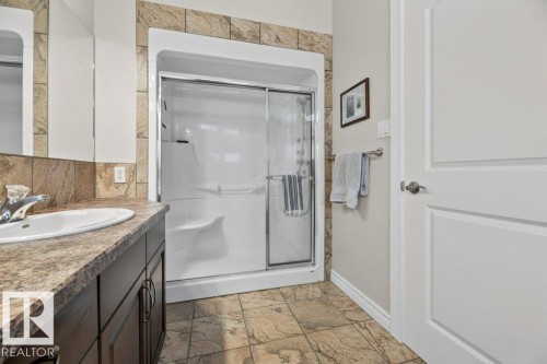 Walk-in shower with clear glass sliding door, integrated seating, and built-in shelving - 5528 43 Street, Lamont, AB 